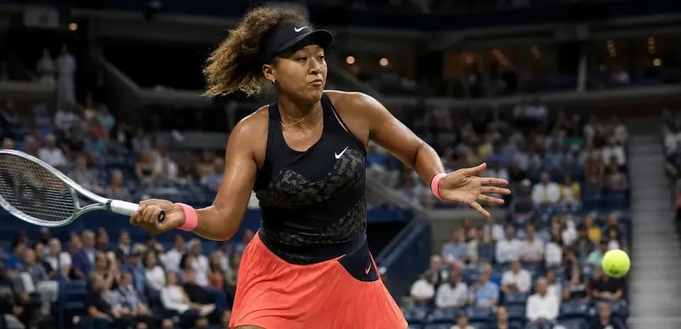 Naomi Osaka golpeando la pelota en partido de tenis