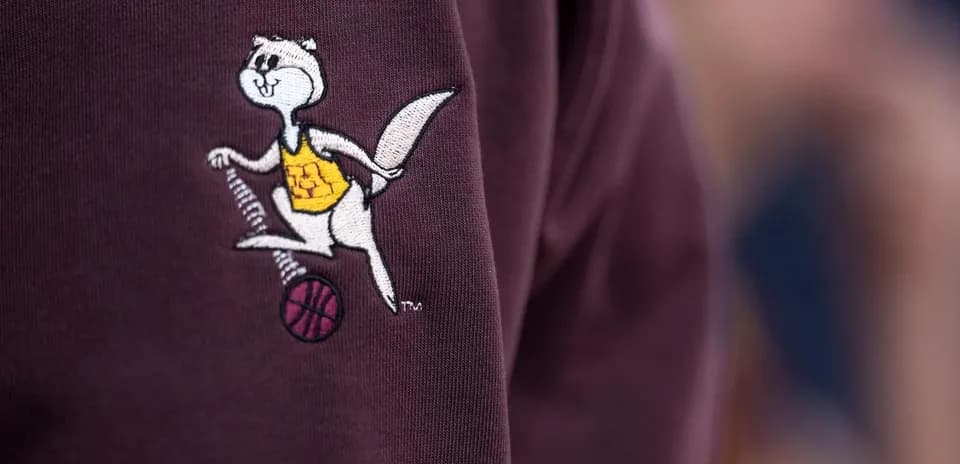 Logotipo de mascota sosteniendo un balón de baloncesto