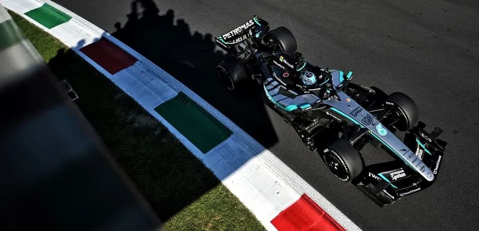 Coche de Fórmula 1 en curva con banderas italianas