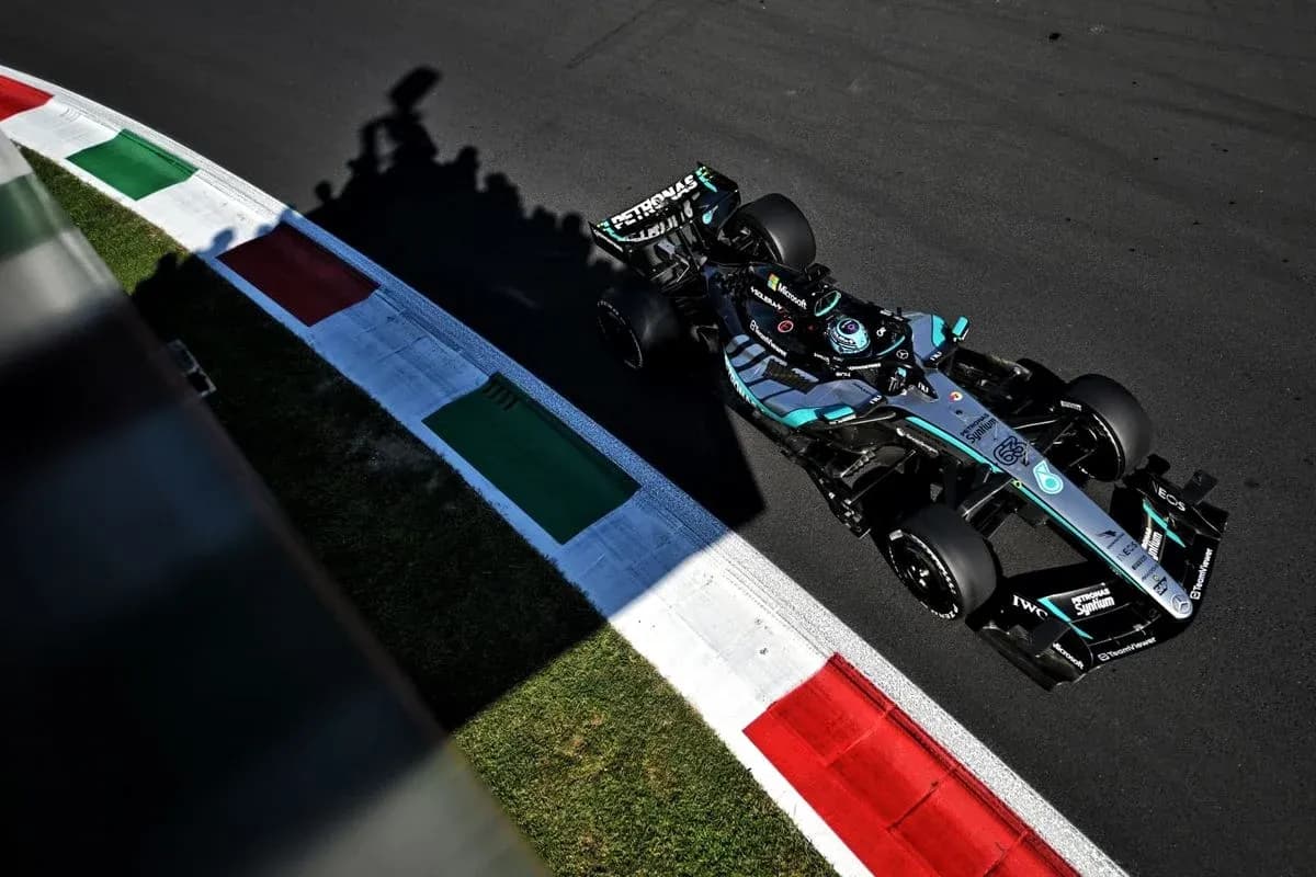 Coche de Fórmula 1 en curva con banderas italianas