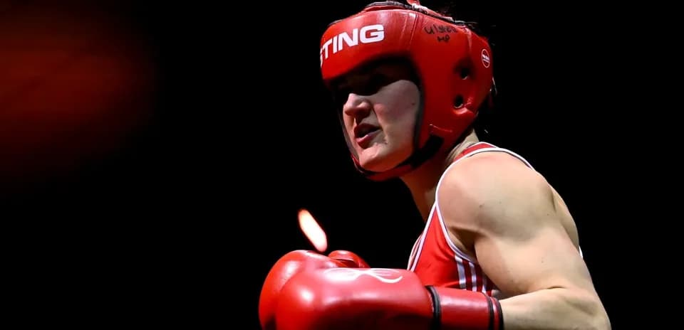 Boxeadora con casco rojo y guantes en acción