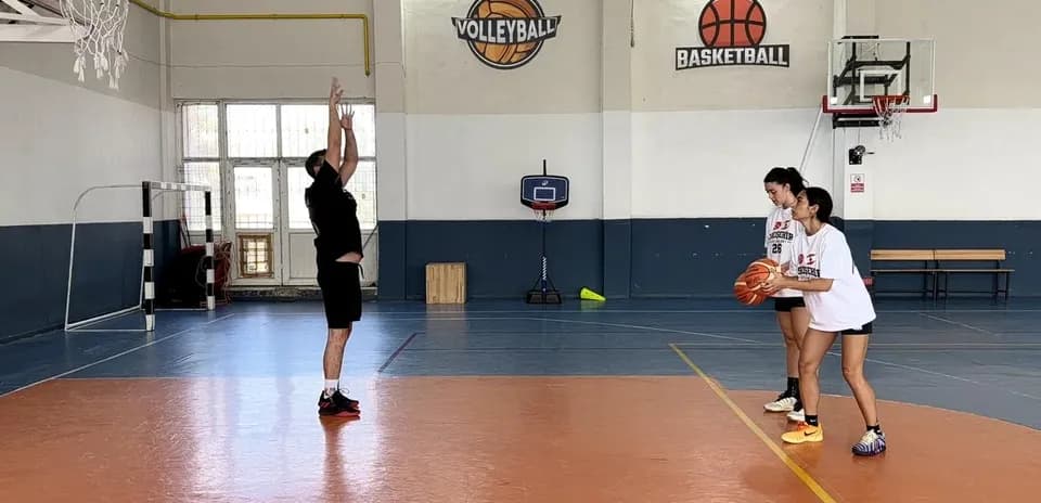 Entrenador enseñando lanzamiento a dos jugadoras