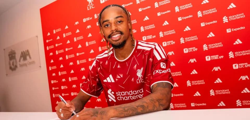 Jugador firmando contrato en mesa de prensa
