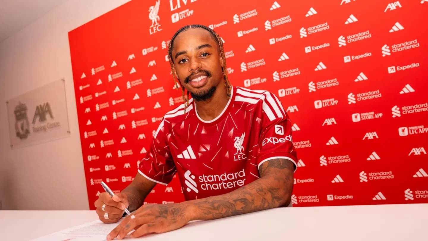 Jugador firmando contrato en mesa de prensa