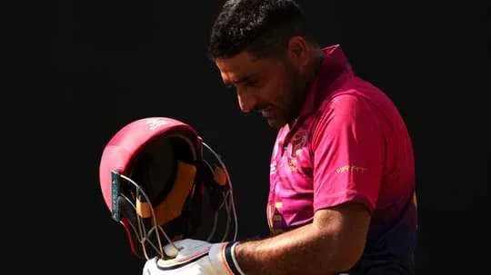 Jugador de cricket sosteniendo su casco antes de jugar