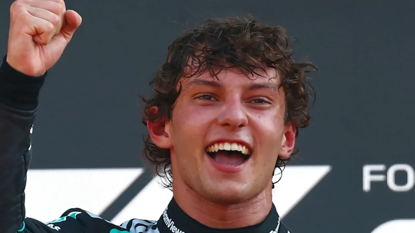 Piloto celebrando con el puño en alto en podio