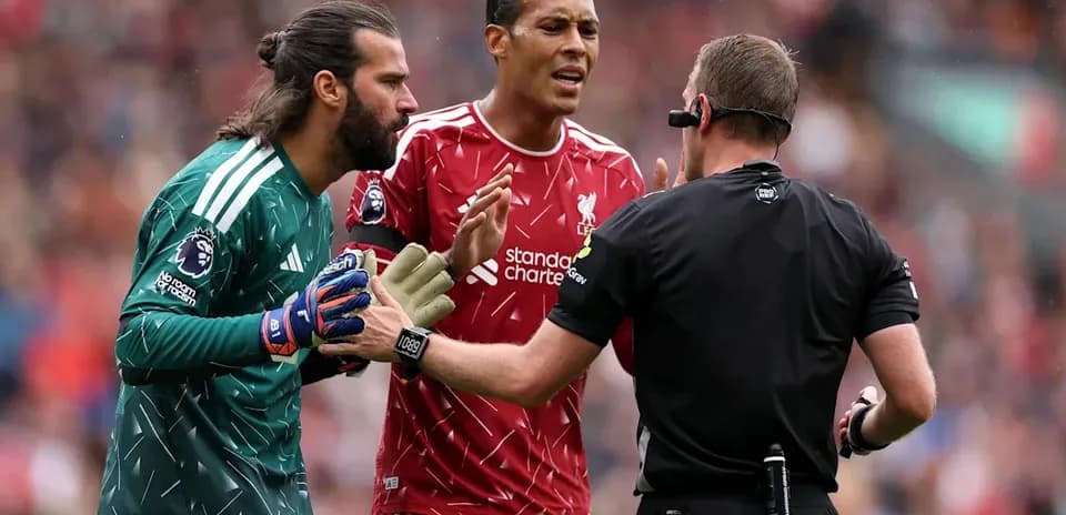 Jugadores de Liverpool discutiendo con el árbitro