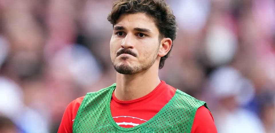 Jugador en el banquillo con chaleco verde