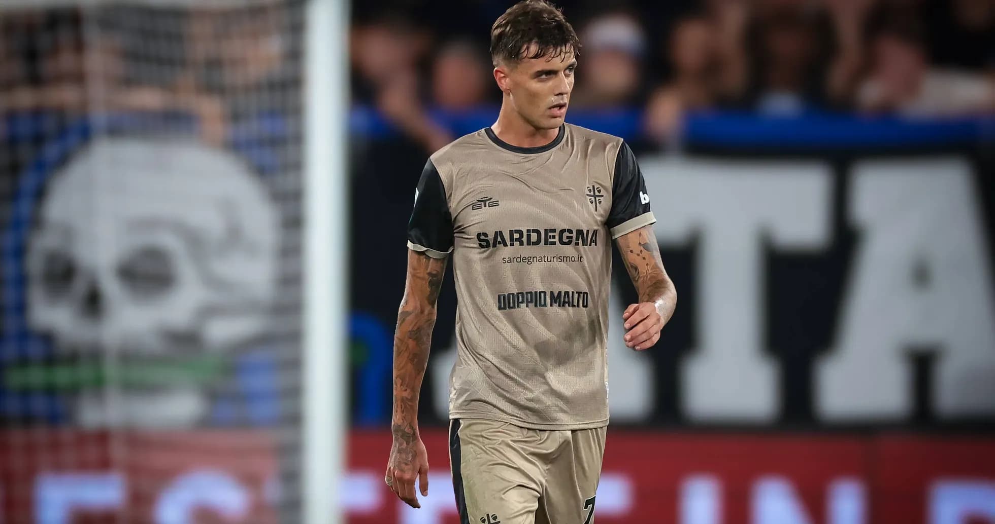 Jugador caminando en el campo con camiseta de Cagliari