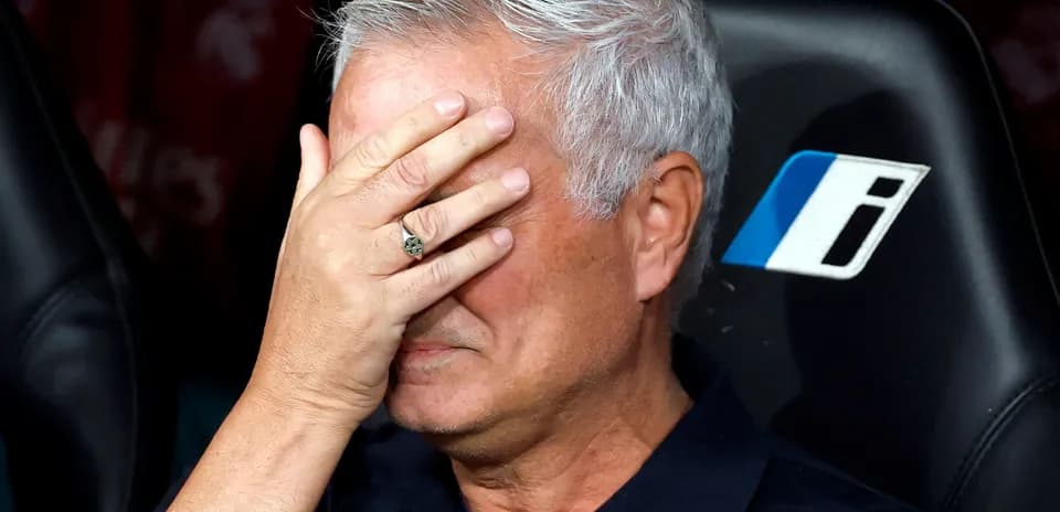 Entrenador cubriendo su rostro con la mano en el banquillo