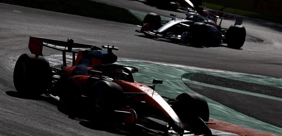 Autos de Fórmula 1 tomando una curva en la pista