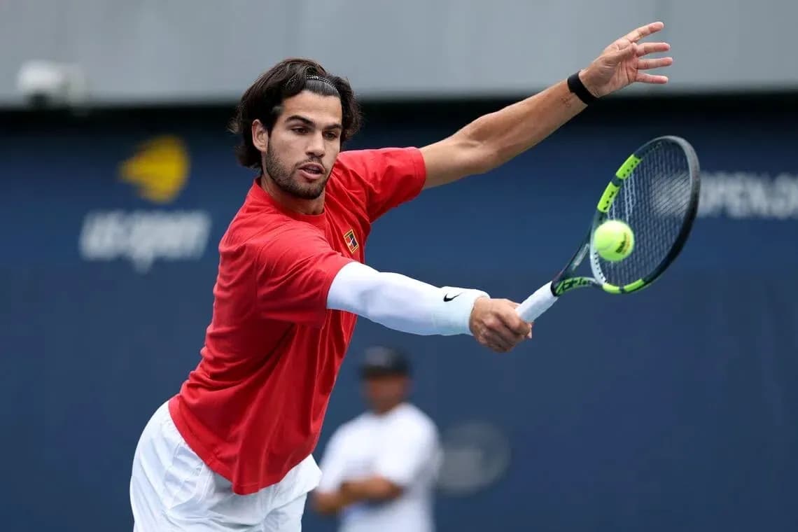 Jugador de tenis golpeando una pelota en la cancha