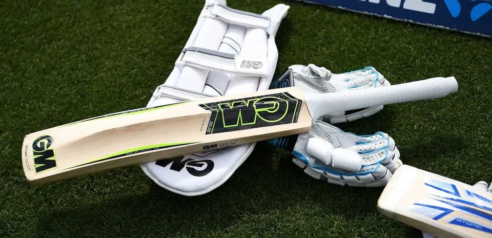 Bate de cricket y equipo en campo de juego