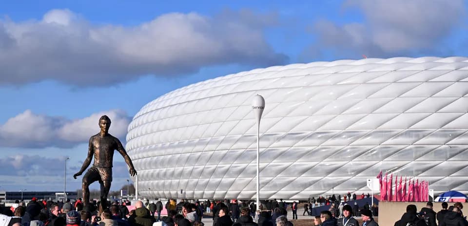 Estatua de jugador frente al Allianz Arena lleno de aficionados