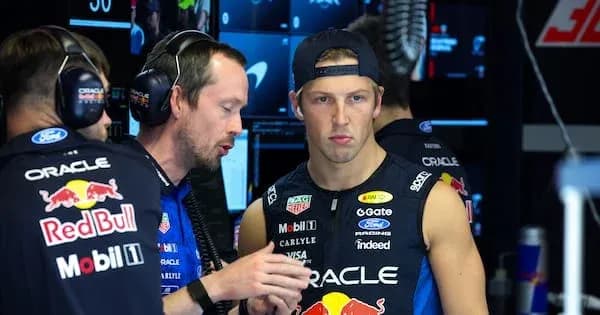 Mecánico hablando con piloto en garaje de equipo