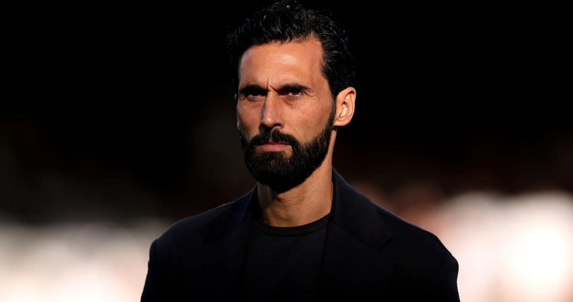 Hombre con barba en un fondo oscuro