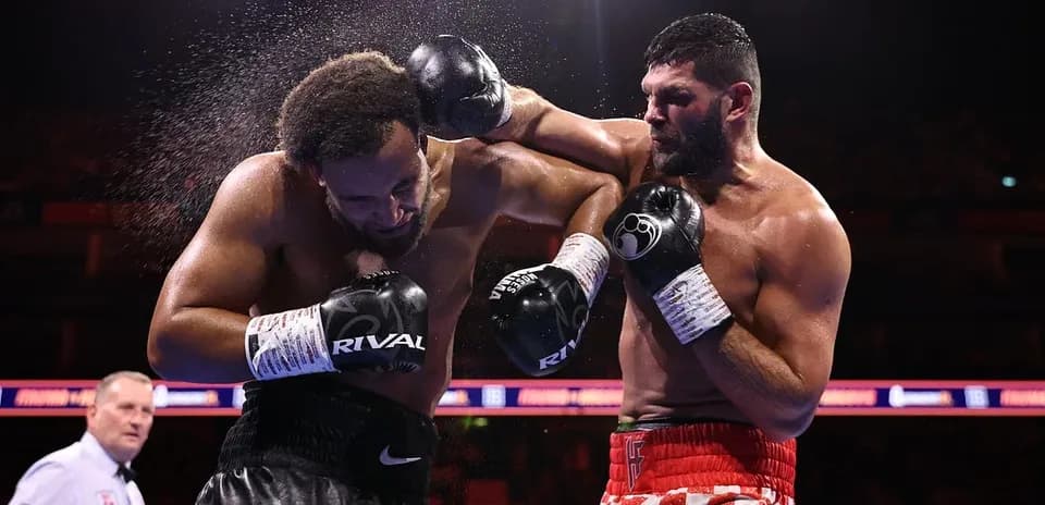 Boxeadores golpeándose en el ring durante combate