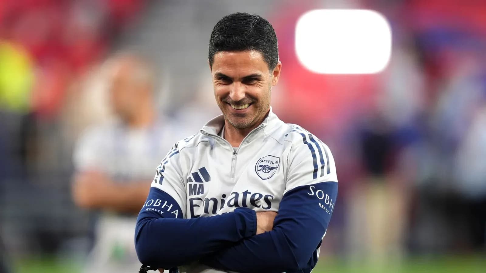 Entrenador de Arsenal sonriendo en el campo