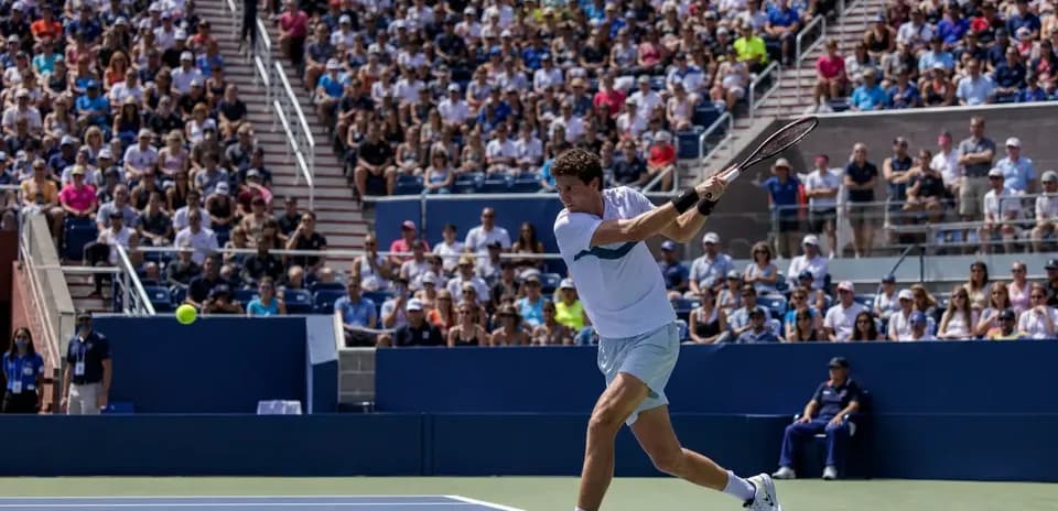 Jugador golpeando la pelota durante un partido de tenis