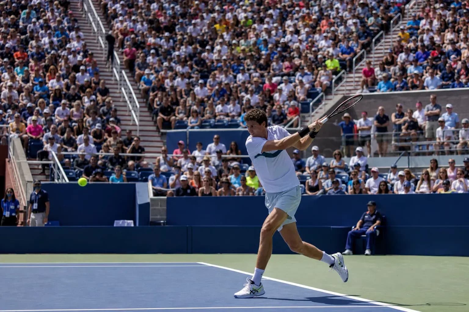 Jugador golpeando la pelota durante un partido de tenis