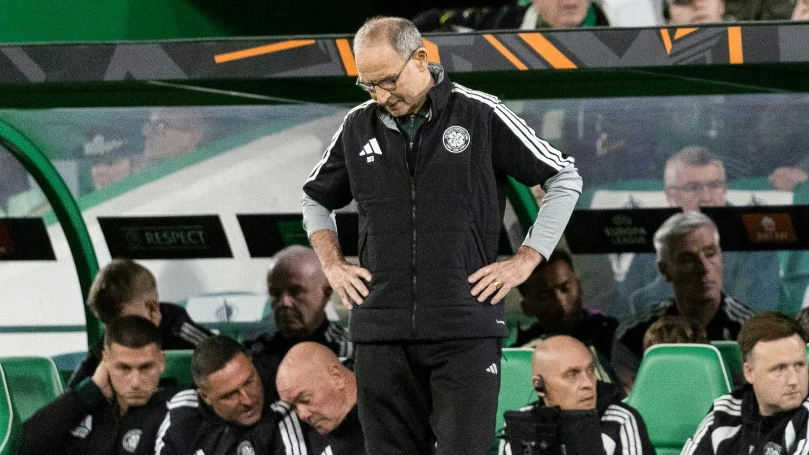 Entrenador mirando al suelo en el banquillo