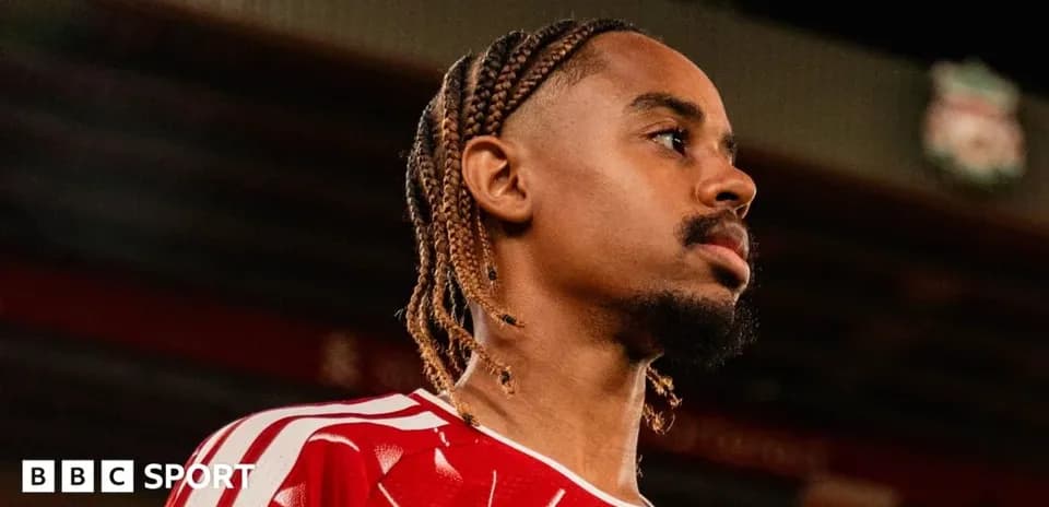 Jugador con trenzas en camiseta roja mirando al frente