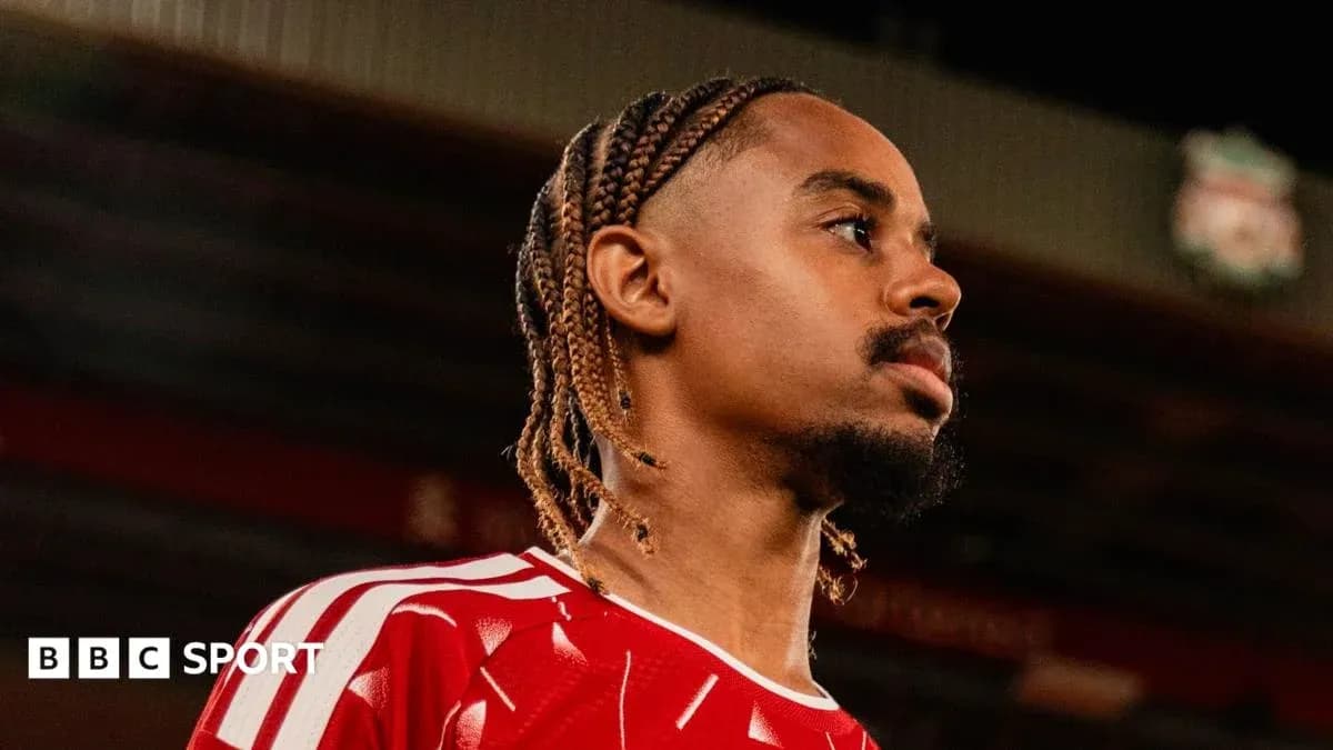 Jugador con trenzas en camiseta roja mirando al frente