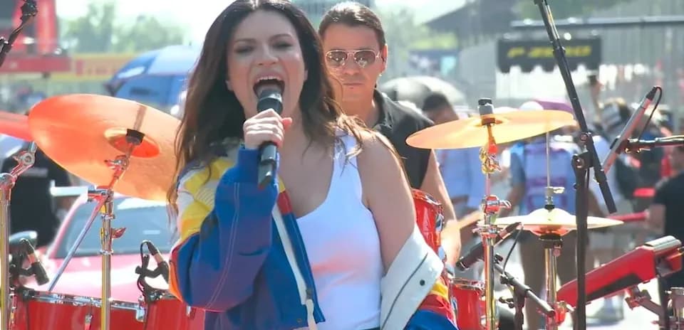 Cantante actuando en escenario con banda de fondo