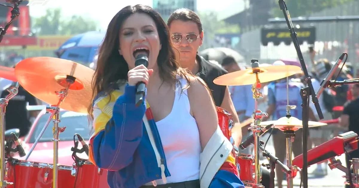 Cantante actuando en escenario con banda de fondo