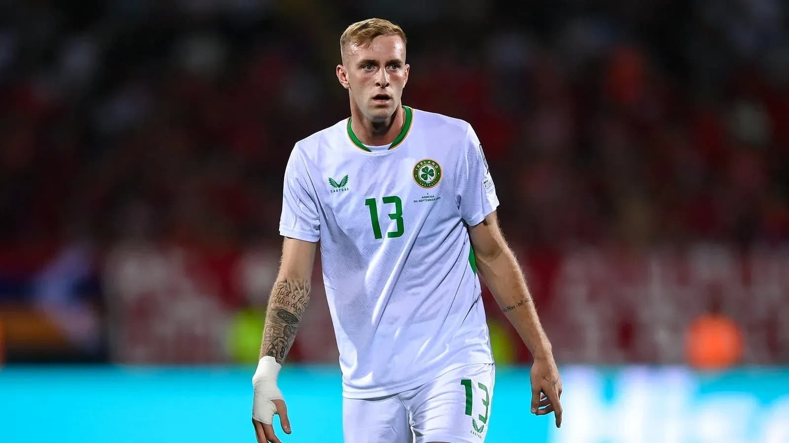 Jugador de fútbol con camiseta blanca de Irlanda en acción