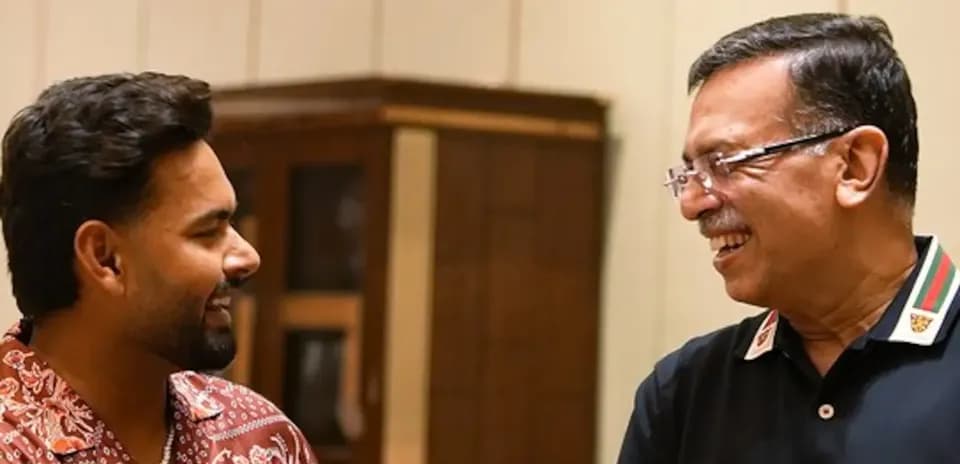 Dos personas sonriendo y conversando en un interior