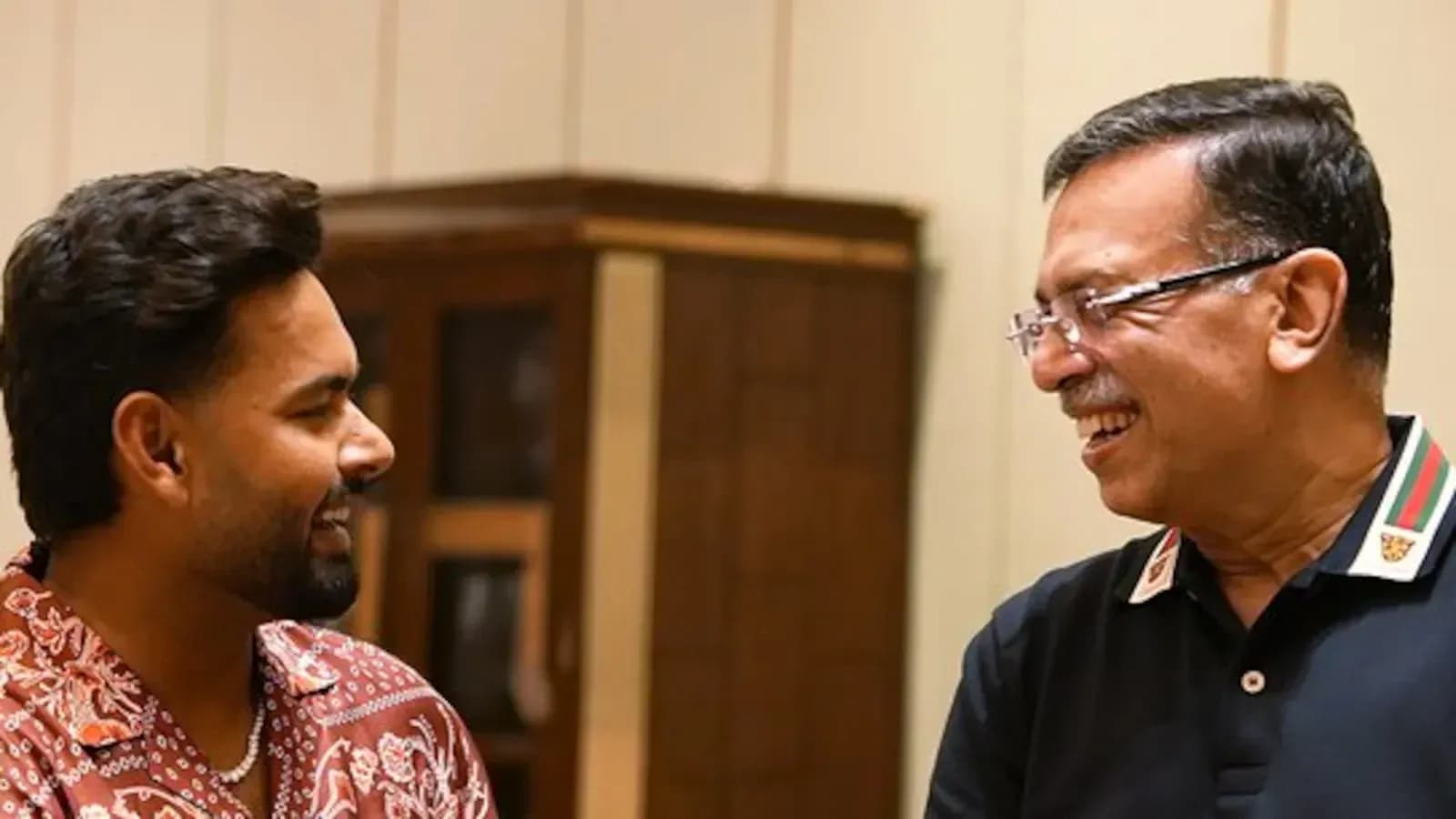 Dos personas sonriendo y conversando en un interior