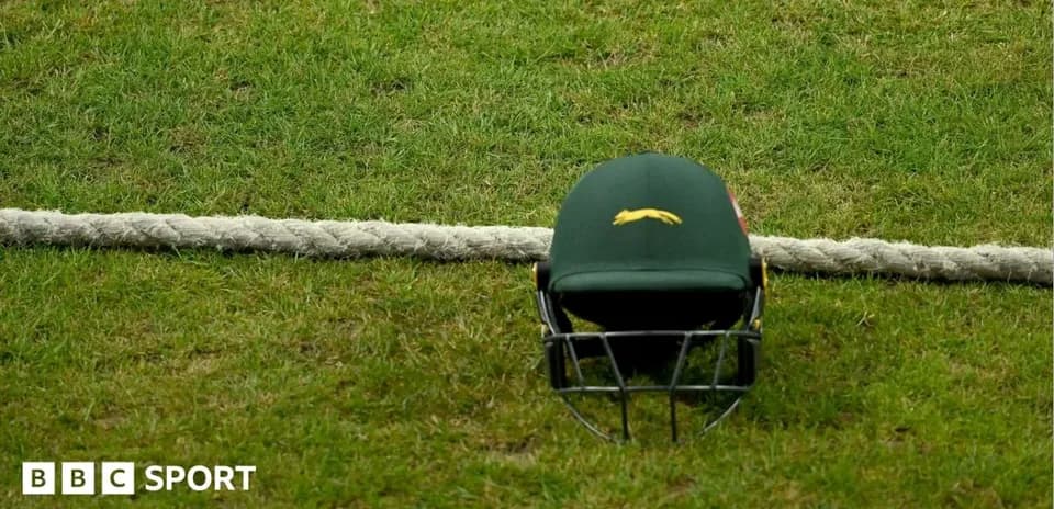 Casco de cricket sobre la hierba junto a una cuerda