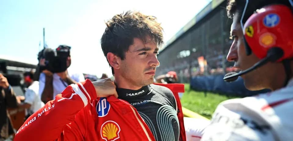 Piloto de Fórmula 1 ajustando su mono en el paddock