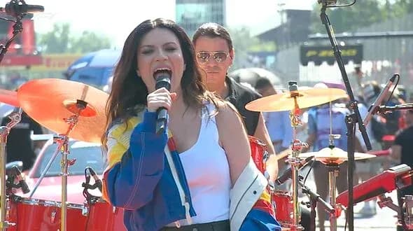 Cantante actuando en un evento musical al aire libre