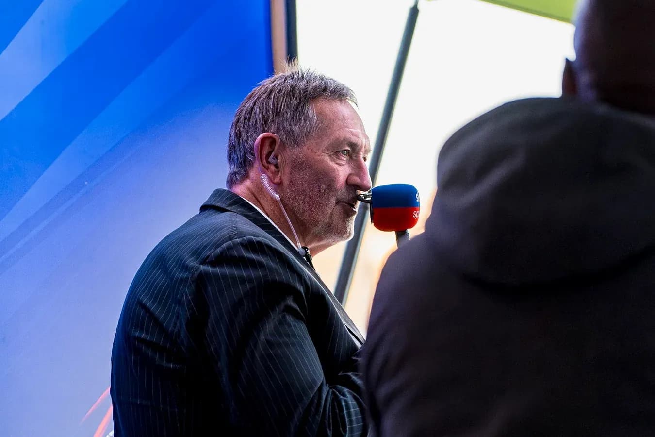 Presentador hablando en un evento deportivo al aire libre
