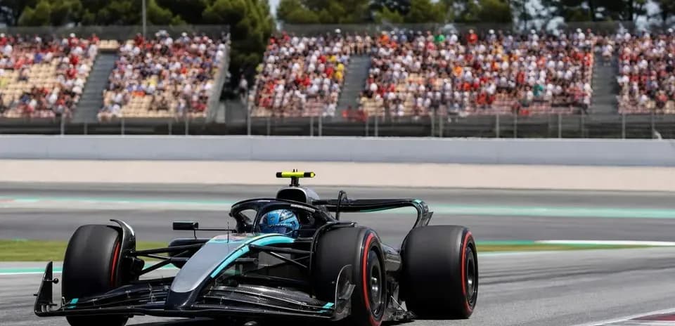 Coche de Fórmula 1 en circuito con espectadores