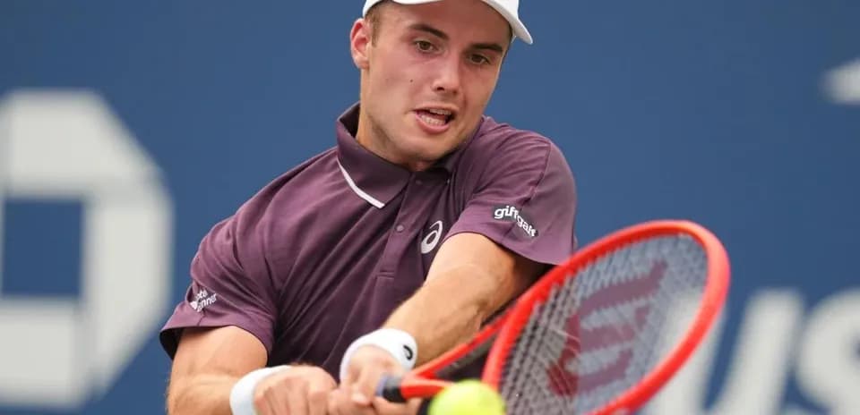 Jugador de tenis golpeando la pelota en la cancha