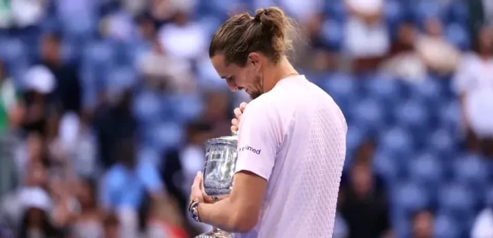 Jugador sosteniendo trofeo tras ganar torneo de tenis