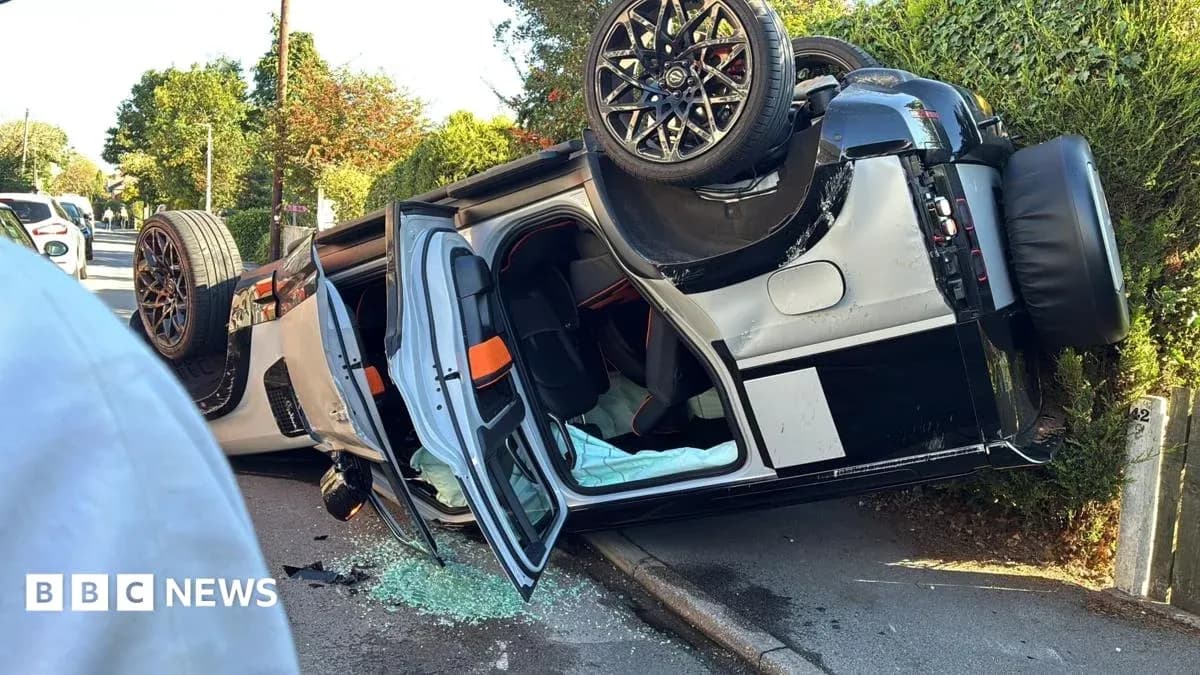 Coche volcado en la acera con cristales rotos