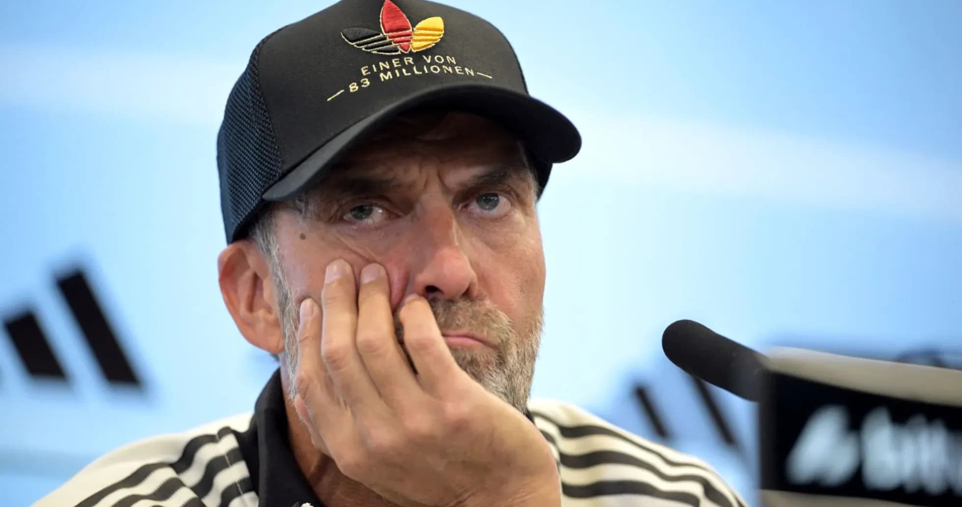 Entrenador en rueda de prensa con mano en la cara