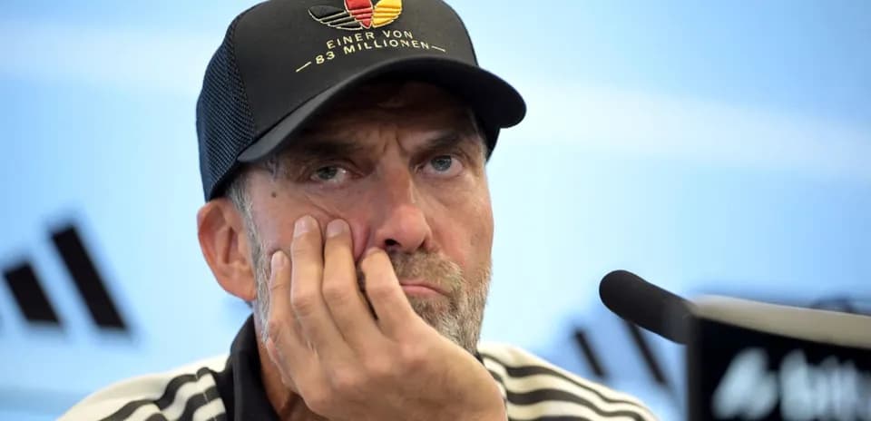 Entrenador en rueda de prensa con mano en la cara