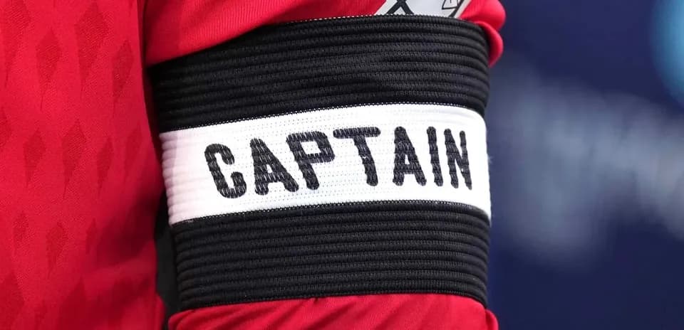 Brazo con cinta de capitán en camiseta roja