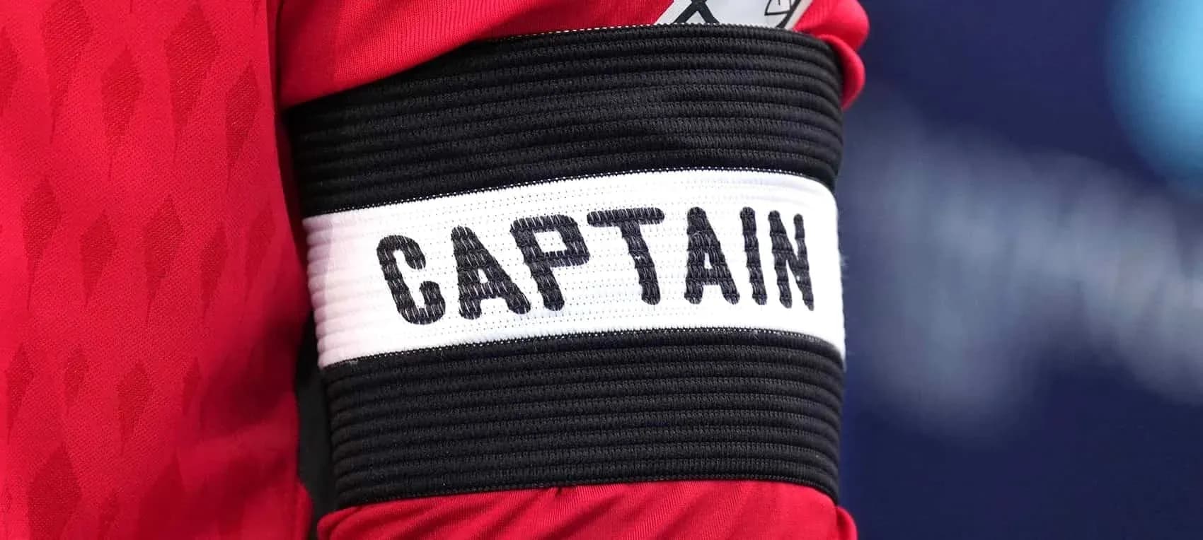Brazo con cinta de capitán en camiseta roja