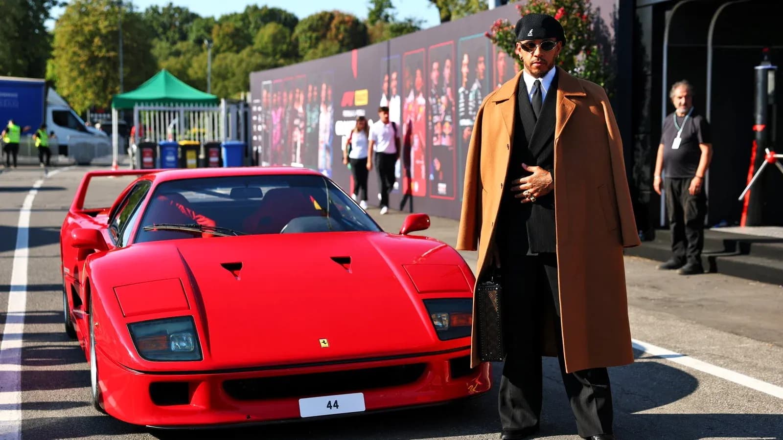 Lewis Hamilton junto a un Ferrari rojo en evento