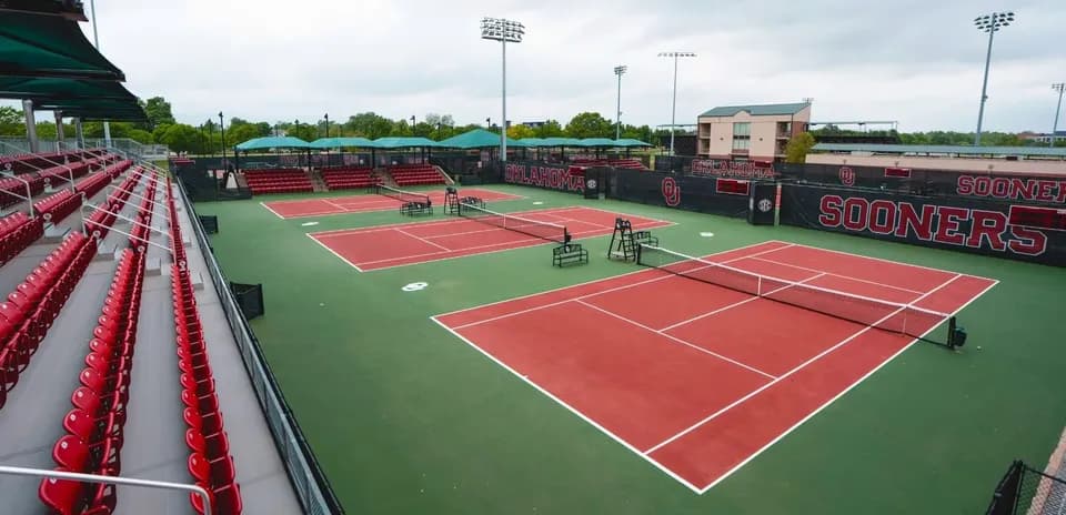 Cancha de tenis con gradas en el fondo
