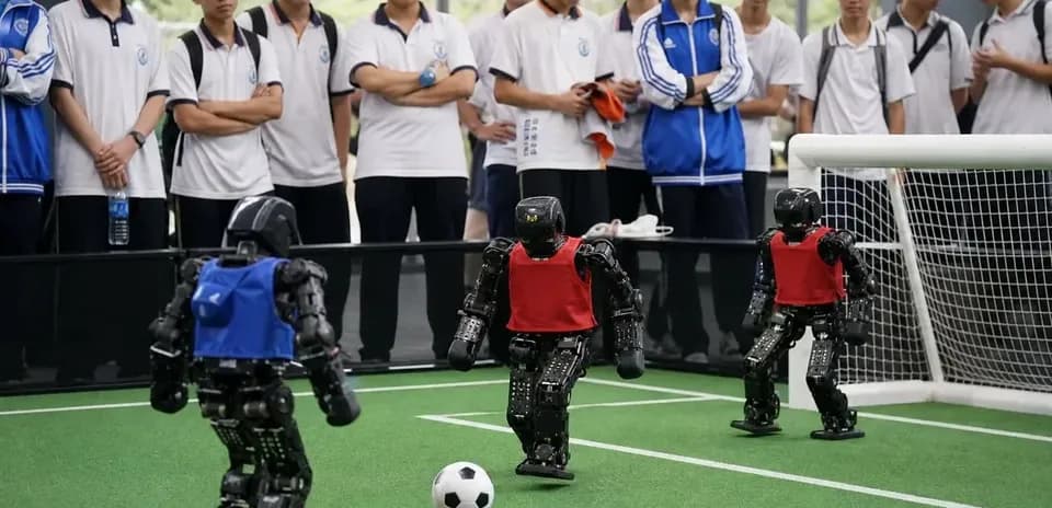Robots playing soccer in front of spectators