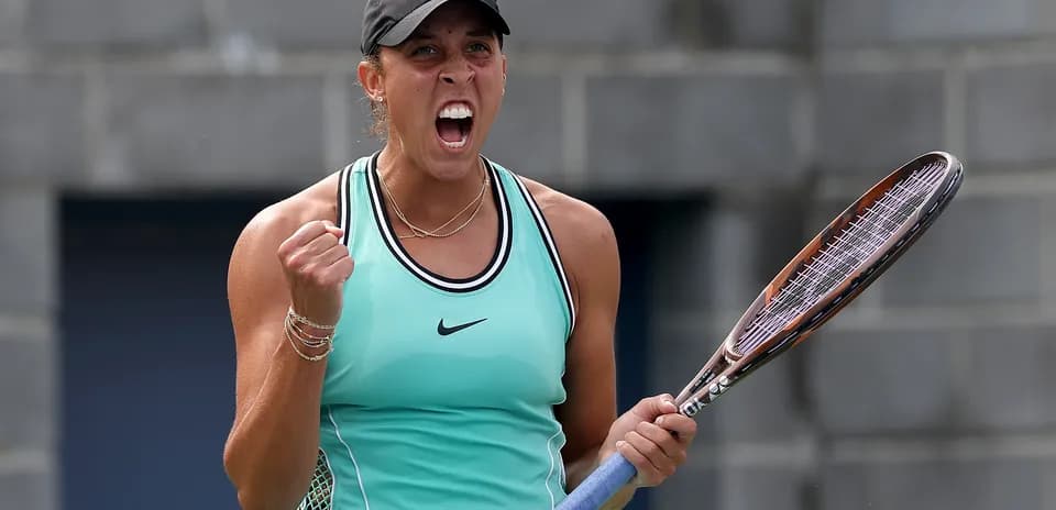 Jugadora de tenis celebrando con raqueta en mano