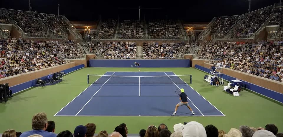 Partido de tenis en estadio lleno de espectadores