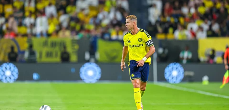 Jugador con camiseta amarilla corriendo tras el balón